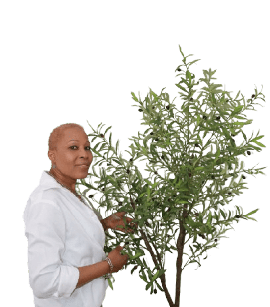 A person tending to a leafy potted plant indoors.